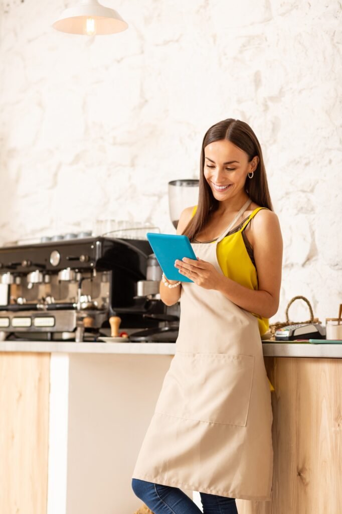 Businesswoman holding tablet while ordering coffee for her cafeteria